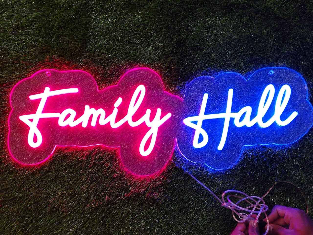 White neon sign displaying the text "Family Hall" in clean, modern font