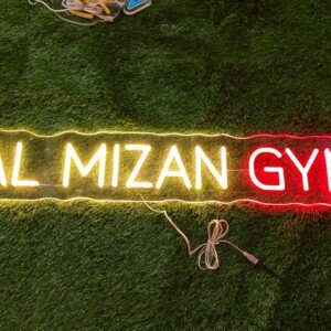 White neon sign displaying a custom gym name in strong, bold lettering