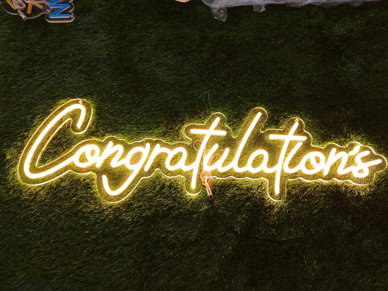 White neon sign displaying the word "Congratulations" in elegant cursive