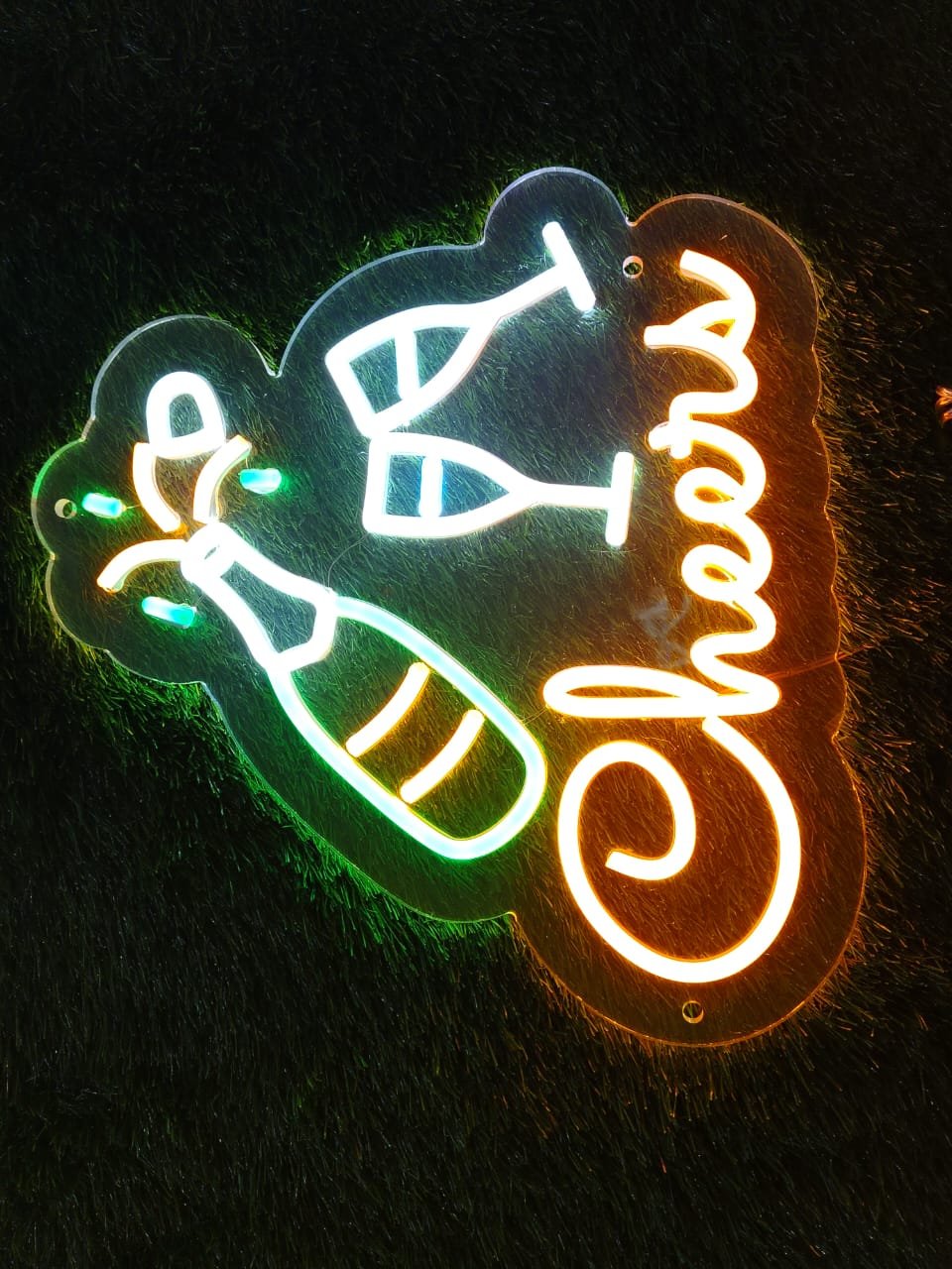 Custom neon sign with the word "Cheers" and glowing icons of a bottle and glass, ideal for bars and restaurants.