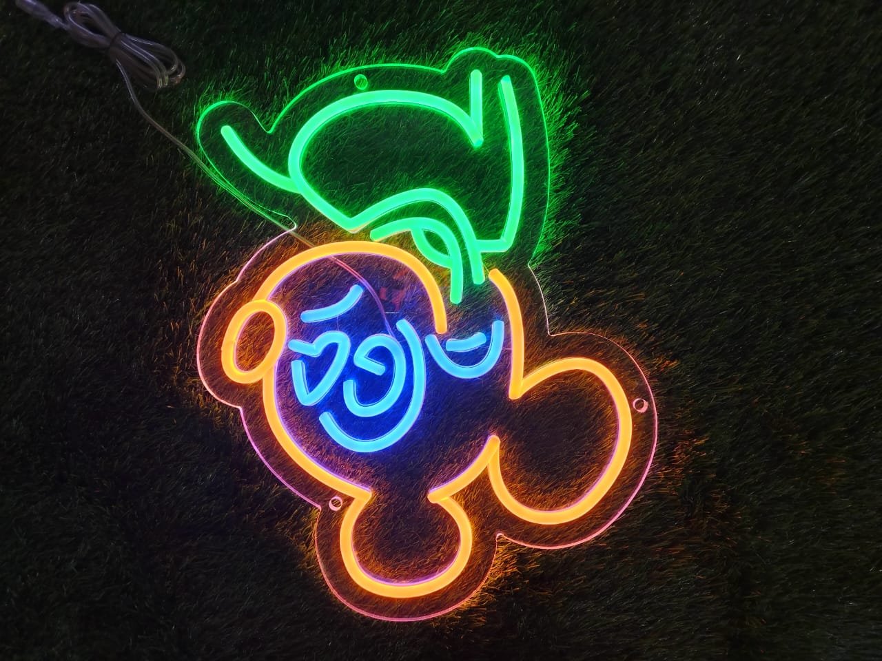 Multicolor cartoon-style neon sign featuring playful animated character or design.