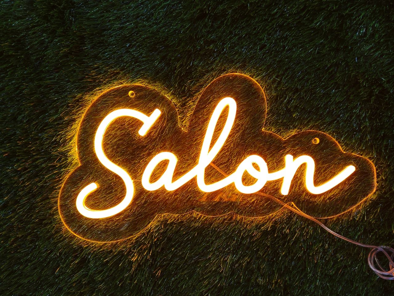 Neon sign featuring a custom saloon or salon name in bright, elegant light — perfect for grooming or beauty spaces.